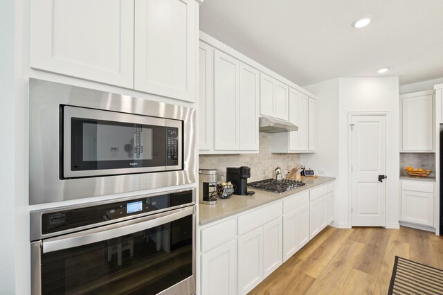 1213 Palmetto Dr, Forney, TX 75126 - kitchen with stainless steel appliances, backsplash, white cabinetry, recessed lighting, and light countertops