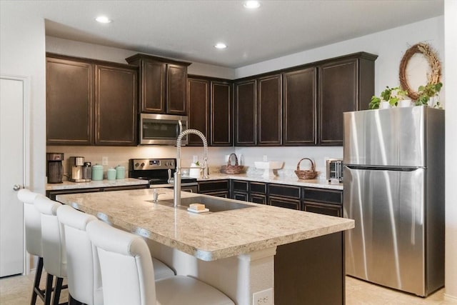2113 Brenham Dr, Forney, TX 75126 - kitchen with stainless steel appliances, dark brown cabinets, a sink, light countertops, and recessed lighting