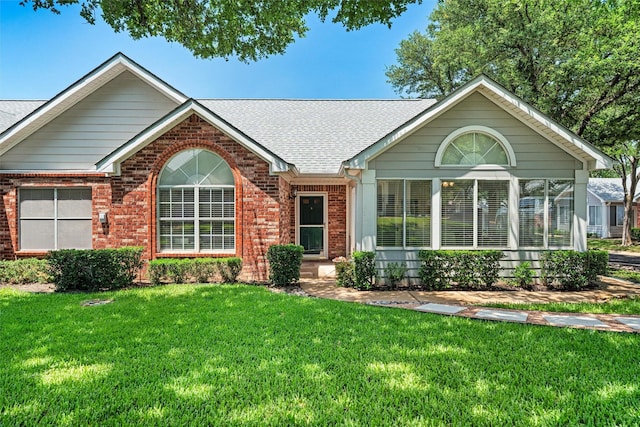 908 Bridges Dr, Arlington, TX 76012 - ranch-style home with brick siding, roof with shingles, and a front lawn
