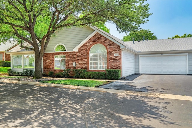 908 Bridges Dr, Arlington, TX 76012 - view of front of house featuring driveway, brick siding, and an attached garage