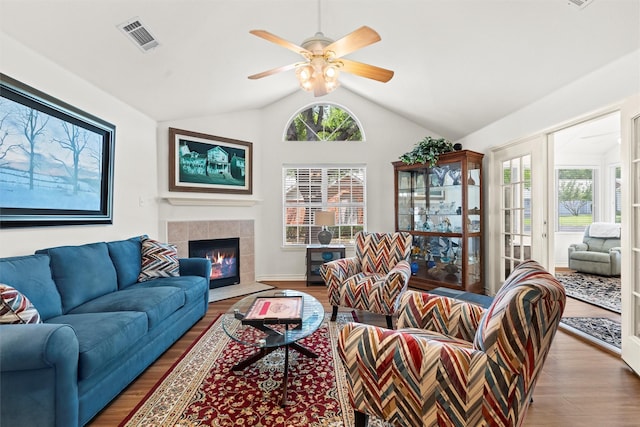 908 Bridges Dr, Arlington, TX 76012 - living room featuring wood finished floors, vaulted ceiling, a tiled fireplace, and ceiling fan