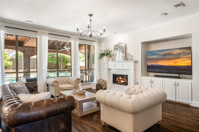 913 Bristlewood Dr, Mckinney, TX 75072 - living area featuring dark wood-style floors, a chandelier, crown molding, and a fireplace