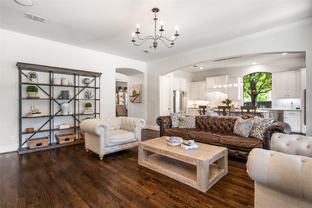 913 Bristlewood Dr, Mckinney, TX 75072 - living room with arched walkways, a chandelier, wood finished floors, ornamental molding, and baseboards