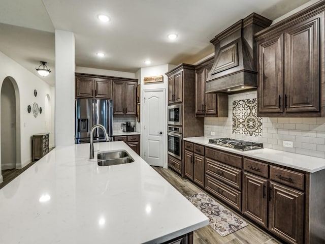 5216 Troupe Rd, Mckinney, TX 75071 - kitchen with appliances with stainless steel finishes, a sink, light wood finished floors, dark brown cabinetry, and light countertops