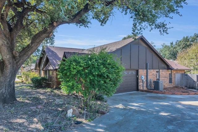 4509 Castle Combe Pl, North Richland Hills, TX 76180 - view of side of property with central air condition unit, brick siding, board and batten siding, driveway, and roof with shingles