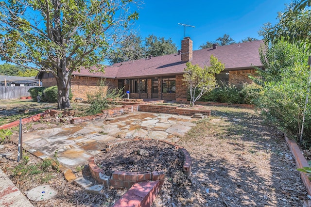 4509 Castle Combe Pl, North Richland Hills, TX 76180 - rear view of property with an outdoor fire pit, brick siding, a patio, a chimney, and a shingled roof