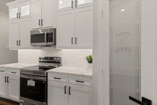 304 Pearl Harbor St, Tool, TX 75143 - kitchen featuring appliances with stainless steel finishes, backsplash, white cabinets, glass insert cabinets, and crown molding