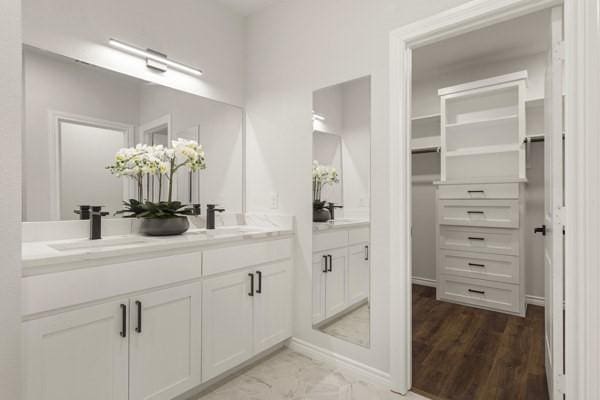 304 Pearl Harbor St, Tool, TX 75143 - bathroom featuring double vanity, a spacious closet, marble finish flooring, and baseboards