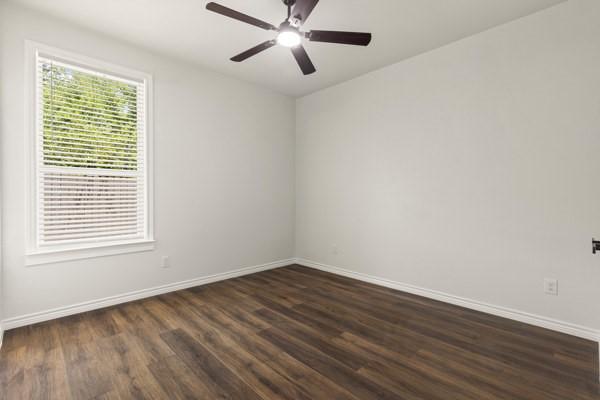 304 Pearl Harbor St, Tool, TX 75143 - unfurnished room featuring baseboards, dark wood-style floors, and ceiling fan