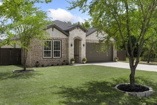 304 Pearl Harbor St, Tool, TX 75143 - view of front of property with board and batten siding, an attached garage, driveway, brick siding, and stone siding