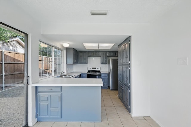 1713 Arvada Dr, Richardson, TX 75081 - kitchen featuring appliances with stainless steel finishes, a peninsula, light tile patterned flooring, light countertops, and a sink