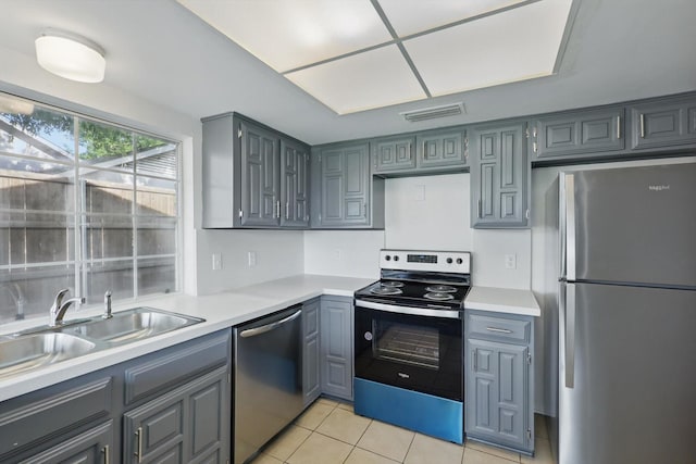 1713 Arvada Dr, Richardson, TX 75081 - kitchen featuring stainless steel appliances, gray cabinetry, a sink, and light tile patterned flooring