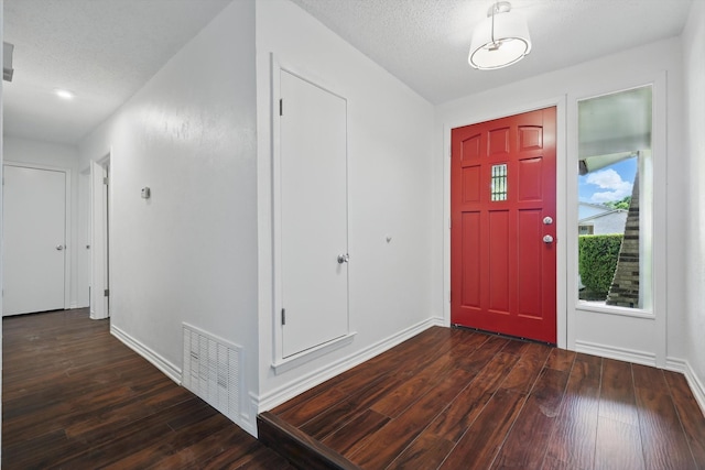 1713 Arvada Dr, Richardson, TX 75081 - entrance foyer with dark wood finished floors, baseboards, and a textured ceiling