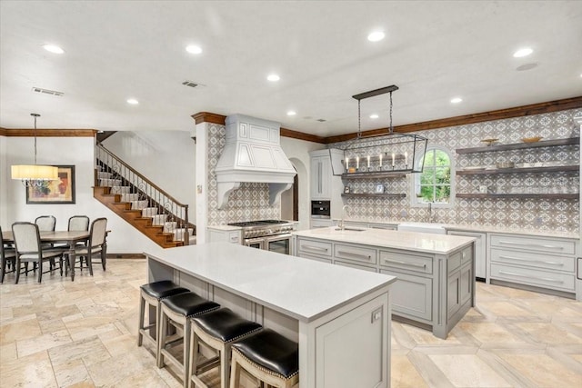 5909 Kittansett Ct, Fort Worth, TX 76132 - kitchen featuring open shelves, double oven range, an island with sink, gray cabinets, and a sink