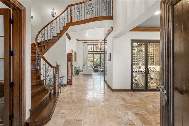 5909 Kittansett Ct, Fort Worth, TX 76132 - foyer with stone tile floors, baseboards, stairway, a chandelier, and a towering ceiling