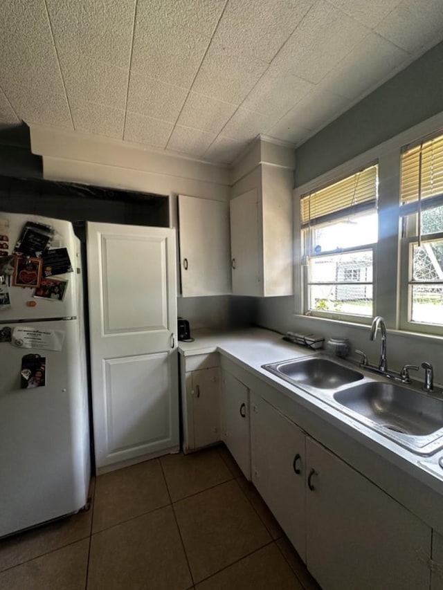 2616 Bardot Ln, Bossier City, LA 71111 - kitchen with freestanding refrigerator, a sink, tile patterned flooring, white cabinetry, and light countertops