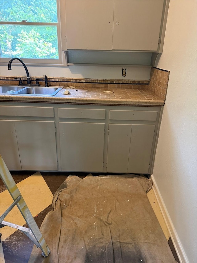 1405 S Hatcher St, Decatur, TX 76234 - kitchen featuring a sink, tile counters, gray cabinets, and baseboards