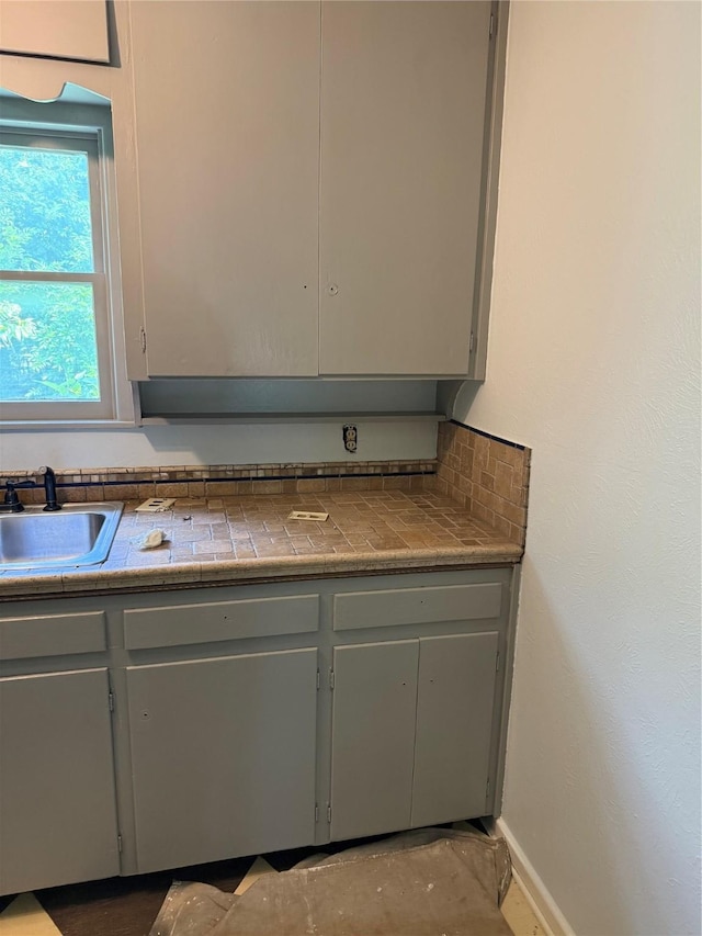1405 S Hatcher St, Decatur, TX 76234 - kitchen featuring a sink, gray cabinetry, and baseboards