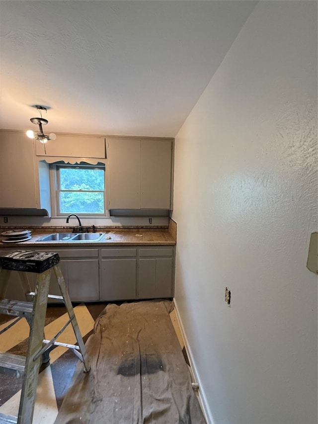 1405 S Hatcher St, Decatur, TX 76234 - kitchen with a sink, baseboards, and gray cabinets