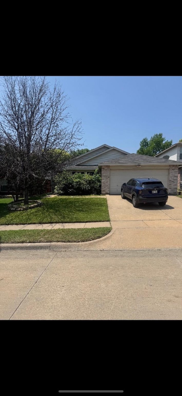 5417 Lansdowne Ave, Fort Worth, TX 76135 - view of front of home with driveway, an attached garage, and a front lawn