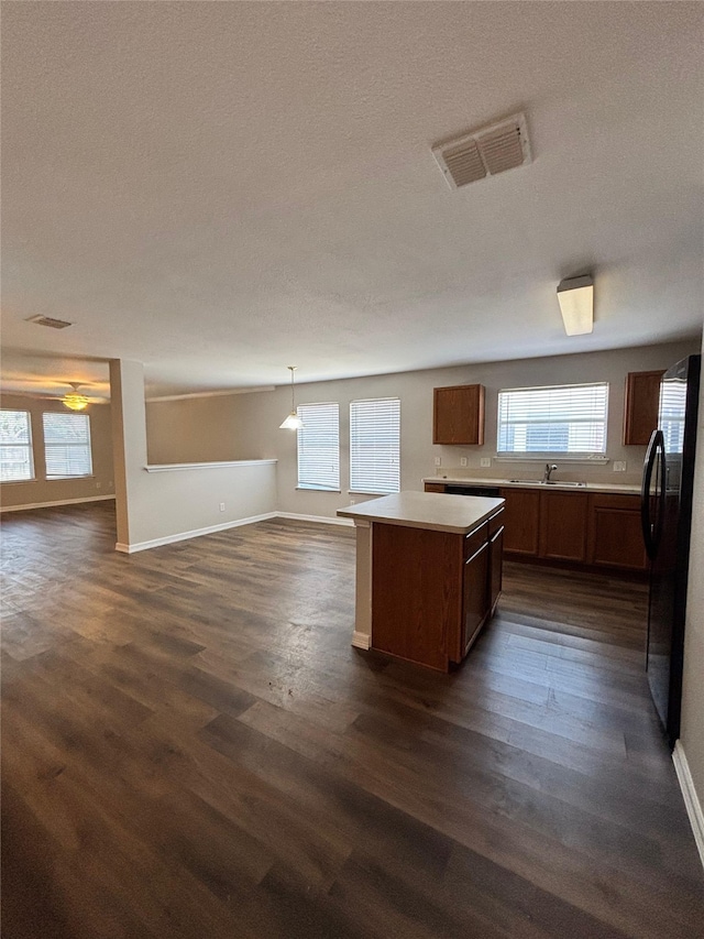 2005 Fairview Dr, Forney, TX 75126 - kitchen with black fridge with ice dispenser, dark wood finished floors, open floor plan, a kitchen island, and a textured ceiling