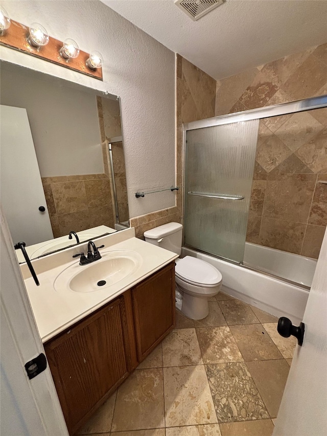 2005 Fairview Dr, Forney, TX 75126 - bathroom with vanity, shower / bath combination with glass door, a textured wall, and a textured ceiling