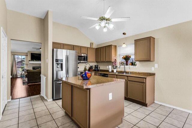 6923 Todd Ln, Sachse, TX 75048 - kitchen featuring stainless steel appliances, ceiling fan, a sink, a center island, and light tile patterned flooring