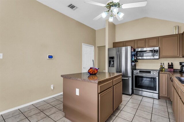 6923 Todd Ln, Sachse, TX 75048 - kitchen featuring stainless steel appliances, light tile patterned flooring, ceiling fan, a center island, and high vaulted ceiling