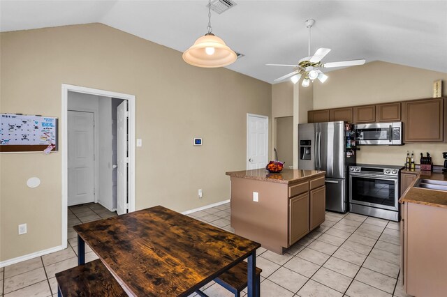 6923 Todd Ln, Sachse, TX 75048 - kitchen featuring appliances with stainless steel finishes, lofted ceiling, ceiling fan, light tile patterned flooring, and a kitchen island