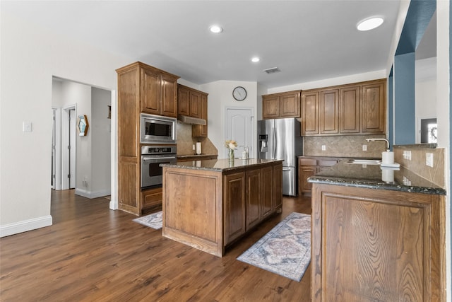 13625 Fishing Hole Ln, Fort Worth, TX 76052 - kitchen with stainless steel appliances, a sink, dark stone counters, backsplash, and a kitchen island with sink