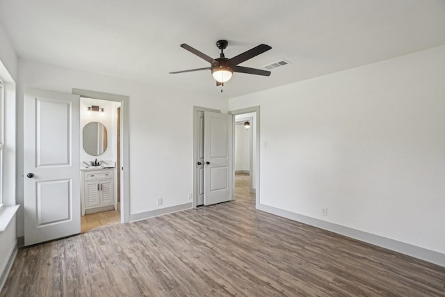 112 Gordon Dr, Azle, TX 76020 - unfurnished bedroom featuring wood finished floors, baseboards, a sink, and ensuite bath