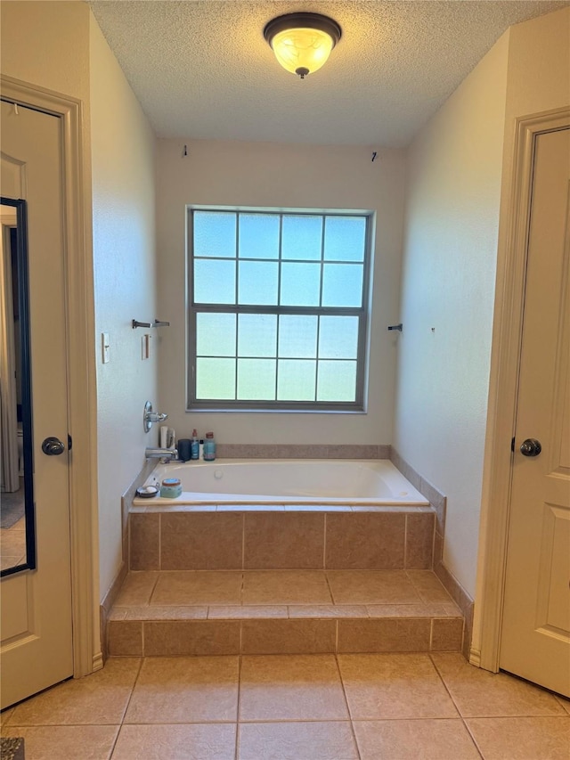 240 County Road 12550, Paris, TX 75462 - bathroom featuring a bath, a textured ceiling, and tile patterned flooring