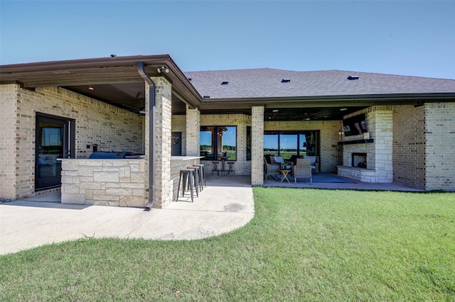139 County Road 2525, Decatur, TX 76234 - back of property featuring exterior fireplace, a patio, brick siding, roof with shingles, and a lawn