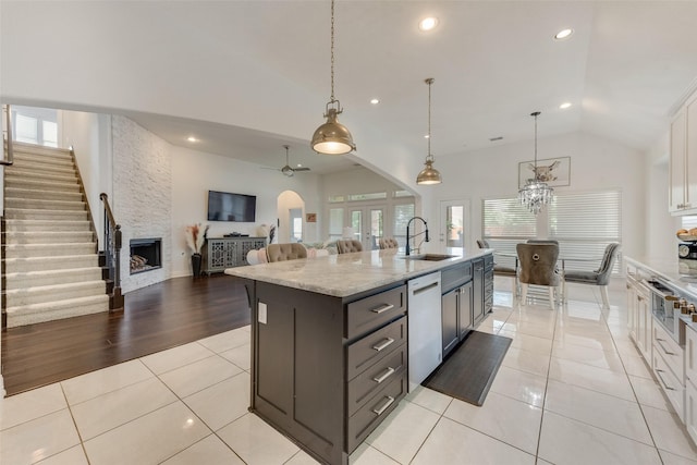 12748 Oakvale Trl, Fort Worth, TX 76244 - kitchen featuring dishwasher, a sink, vaulted ceiling, a center island with sink, and light stone countertops