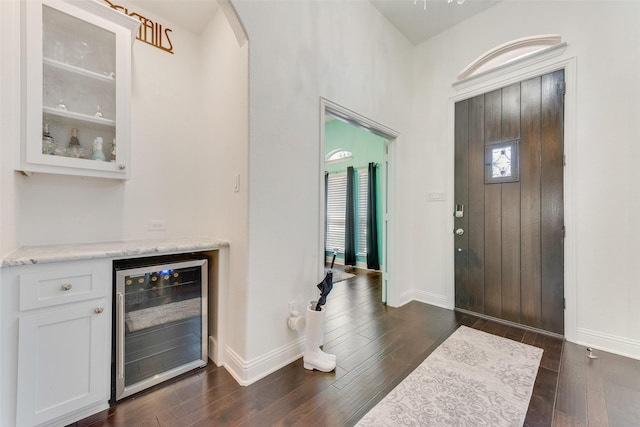 12748 Oakvale Trl, Fort Worth, TX 76244 - foyer featuring wine cooler, a dry bar, arched walkways, dark wood-type flooring, and baseboards