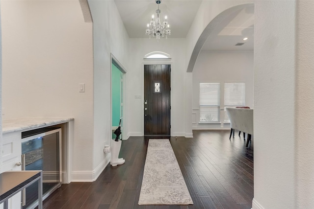 12748 Oakvale Trl, Fort Worth, TX 76244 - entryway with wine cooler, arched walkways, a chandelier, dark wood-type flooring, and baseboards
