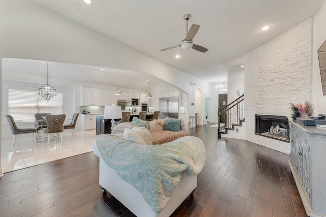 12748 Oakvale Trl, Fort Worth, TX 76244 - living area with a ceiling fan, arched walkways, dark wood-type flooring, vaulted ceiling, and stairway