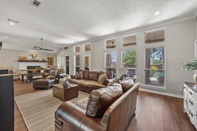 509 Windsor Way, Rockwall, TX 75087 - living area with dark wood-style flooring, a brick fireplace, crown molding, recessed lighting, and vaulted ceiling