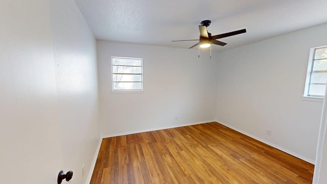 2013 S High St, Brady, TX 76825 - empty room with a ceiling fan, healthy amount of natural light, wood finished floors, and baseboards