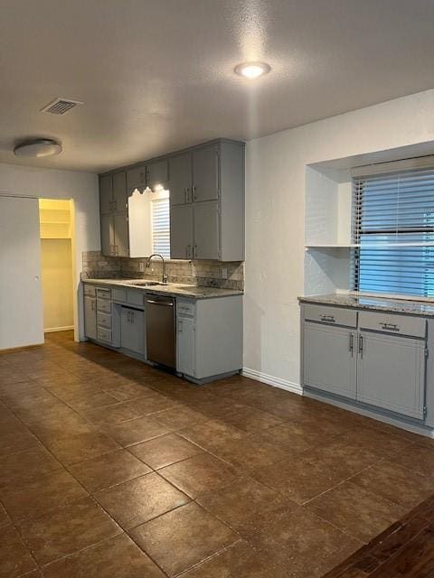 2411 Laredo Ct, Arlington, TX 76015 - kitchen with gray cabinets, stainless steel dishwasher, baseboards, a sink, and decorative backsplash
