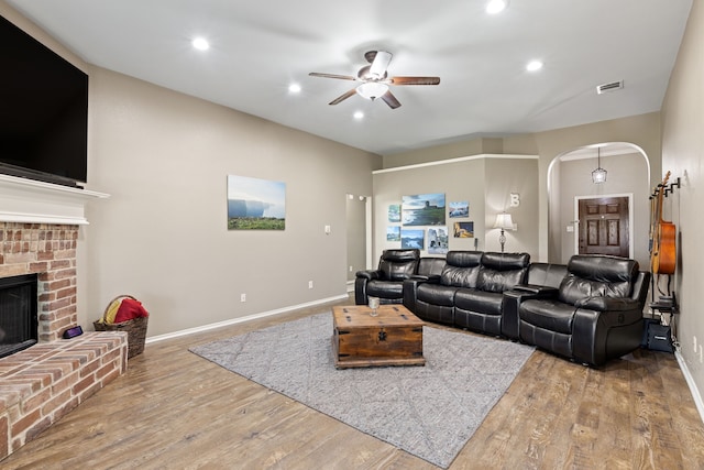305 Margaret St, Fate, TX 75189 - living area with arched walkways, a ceiling fan, wood finished floors, a fireplace, and baseboards