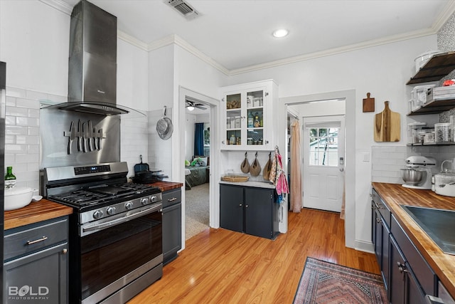 3526 Greenway Pl, Shreveport, LA 71105 - kitchen with butcher block counters, stainless steel gas range, exhaust hood, decorative backsplash, and ornamental molding