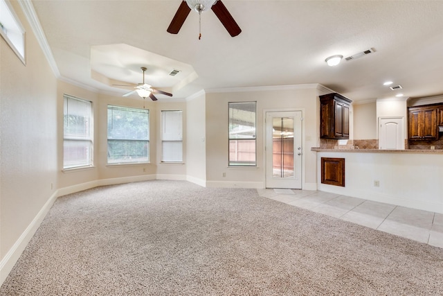 2917 Cascade Dr, Plano, TX 75025 - unfurnished living room featuring a ceiling fan, light carpet, crown molding, baseboards, and a tray ceiling