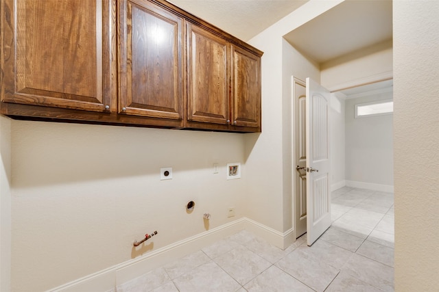2917 Cascade Dr, Plano, TX 75025 - laundry area featuring gas dryer hookup, washer hookup, light tile patterned floors, cabinet space, and baseboards