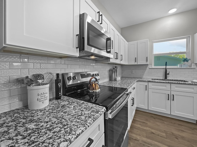 102 Bois D Arc St, Whitesboro, TX 76273 - kitchen featuring appliances with stainless steel finishes, a sink, white cabinetry, and light stone counters