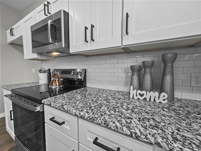 102 Bois D Arc St, Whitesboro, TX 76273 - kitchen with stainless steel appliances, dark stone counters, white cabinets, backsplash, and wood finished floors