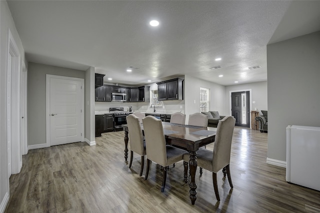 12111 Galva Dr, Dallas, TX 75243 - dining space featuring baseboards, wood finished floors, recessed lighting, and a textured ceiling