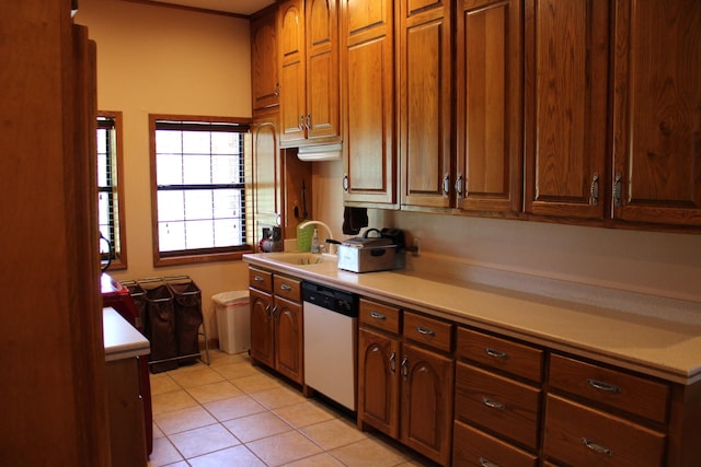 801 County Road 313, Eastland, TX 76448 - kitchen featuring dishwasher, light countertops, light tile patterned floors, a sink, and brown cabinets