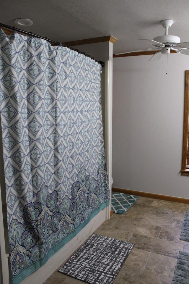 801 County Road 313, Eastland, TX 76448 - full bathroom featuring a ceiling fan, shower / tub combo, baseboards, a textured ceiling, and stone finish floors