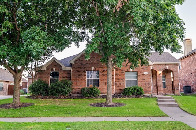1350 Amistad Dr, Prosper, TX 75078 - traditional-style house featuring a front lawn, brick siding, cooling unit, and a shingled roof